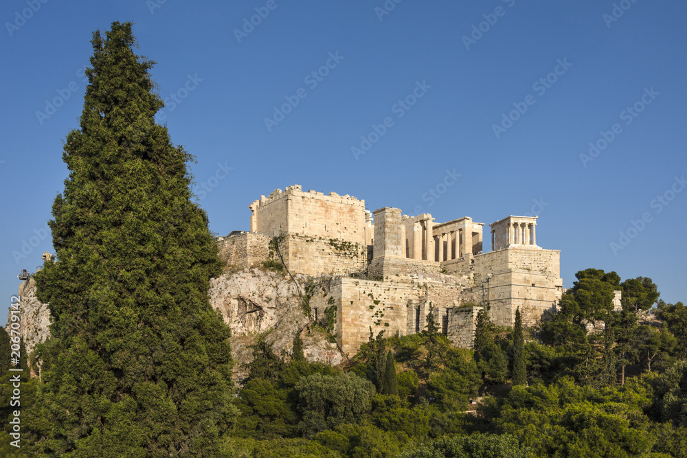 Greece, Athens: Panoramic view of famous Acropolis with people who visit the Parthenon, Erechtheum, Beule Gate and Temple of Athena in the city center of the Greek capital and blue sky. April 26, 2018