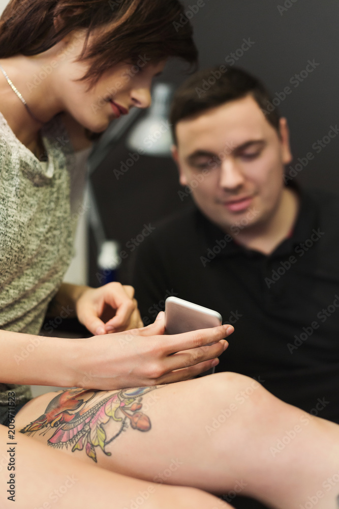 Man and woman choosing tattoo design in studio Man and woman choosing tattoo design in studio