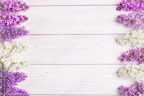 Floral pattern lilac branches and petals on wooden background. Frame.