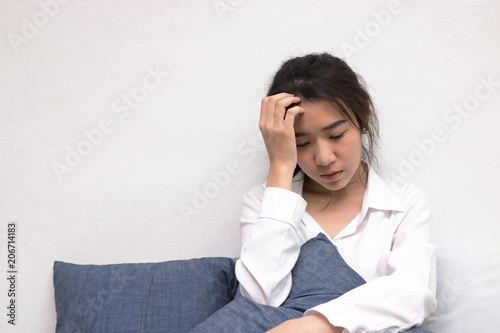 Anxiety depressed young Asian woman with hands on forehead suffering from trouble.