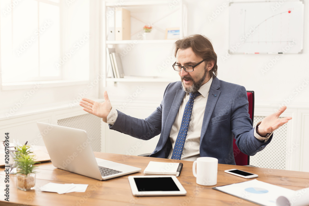 Anxious businessman in suit looking at laptop screen Anxious businessman in suit looking at laptop screen