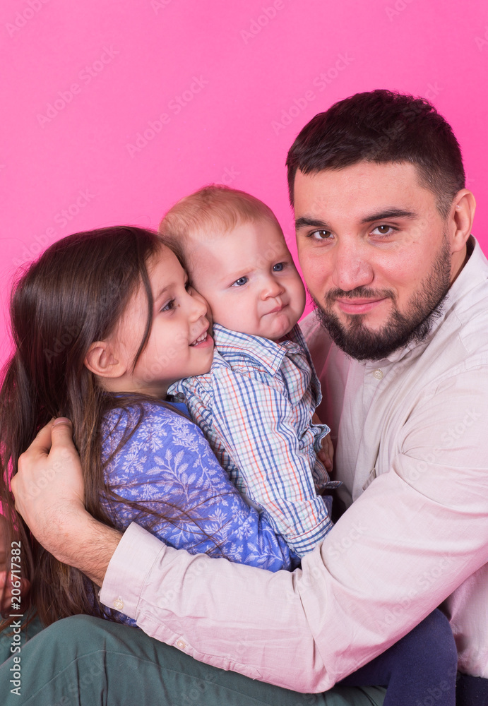 Fototapeta premium Father with children having fun on pink background