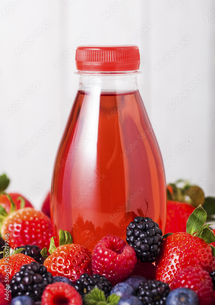 Plastic bottle of berries soda juice drink on wood Plastic bottle of berries soda juice drink on wood