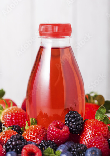 Plastic bottle of berries soda juice drink on wood