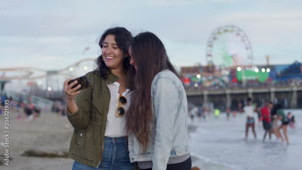 Friends Take Cute Vacation Selfies Together On The Beach, Santa Monica Pier In Background (Shot On Red Scarlet-W Dragon In 4K, Slow Motion) Friends Take Cute Vacation Selfies Together On The Beach, Santa Monica Pier In Background (Shot On Red Scarlet-W Dragon In 4K, Slow Motion)