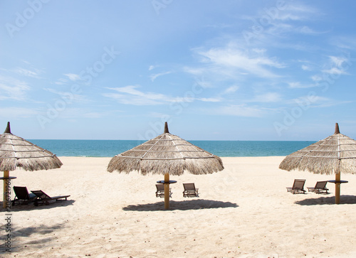 Fototapeta Naklejka Na Ścianę i Meble -  Tropical view of a beach with umbrellas and  beach chairs