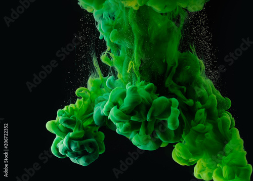 close-up view of green abstract ink explosion on black background