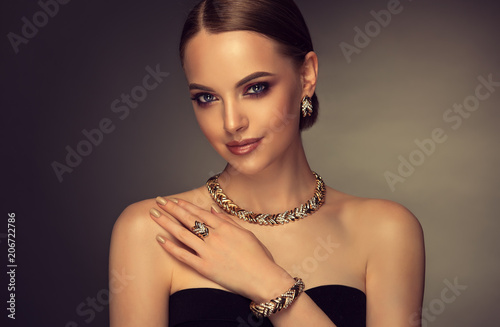 Beautiful girl with set jewelry . Woman in a necklace with a ring, earrings and a bracelet. Beauty and accessories. 

