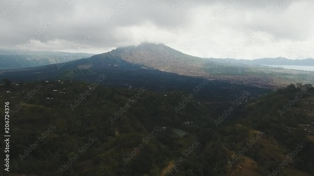 Mountain landscape with volcano, sky with clouds. Aerial view of Mount Batur Volcano in Kintamani. Bali volcano, also referred to as Kintamani is popular sightseeing destination in Bali. Travel Mountain landscape with volcano, sky with clouds. Aerial view of Mount Batur Volcano in Kintamani. Bali volcano, also referred to as Kintamani is popular sightseeing destination in Bali. Travel