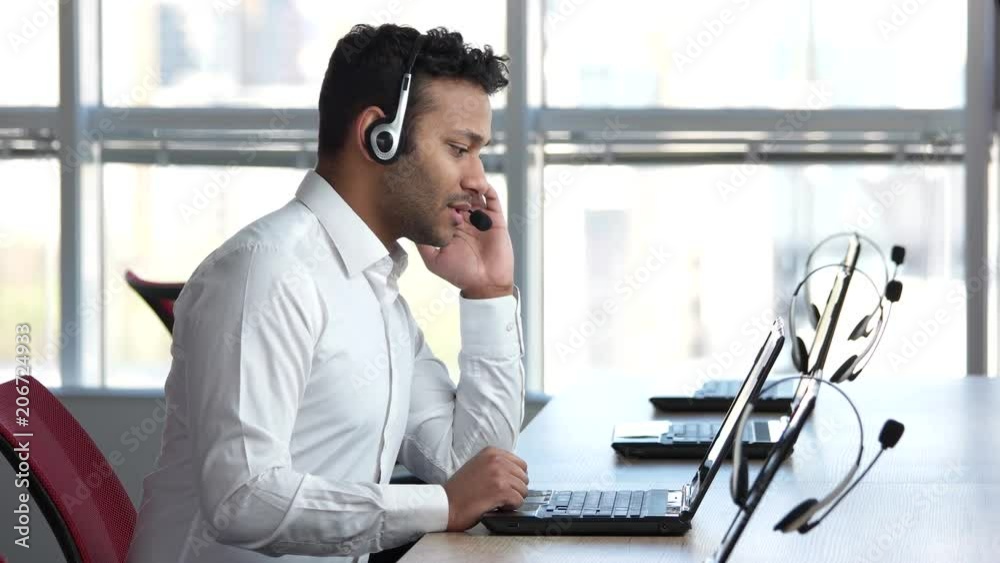 American businessman talking with client online. Spinning on office chair and smile to camera.