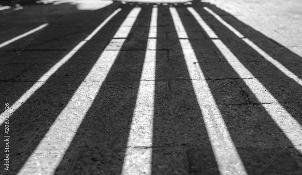 Vertical Lines as Shadows on the stone road Black and white pattern as background