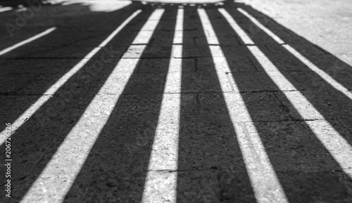 Vertical Lines as Shadows on the stone road Black and white pattern as background