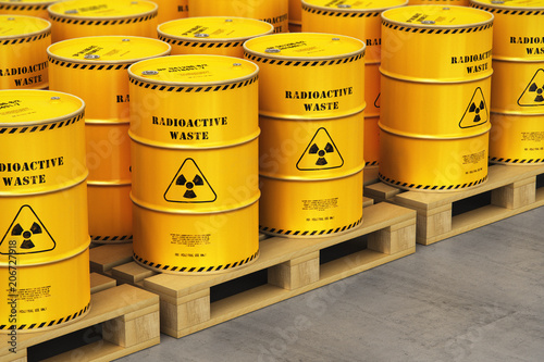 Group of yellow drums with radioactive waste on shipping pallets in warehouse