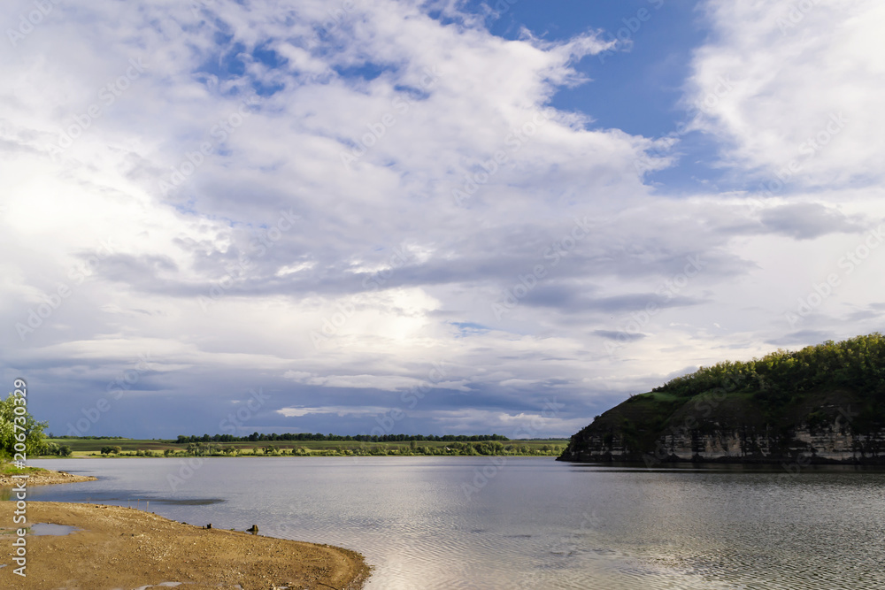 Obraz premium Beautiful river landscape. Calm river with colorful sky reflection on it. River flow on sunset