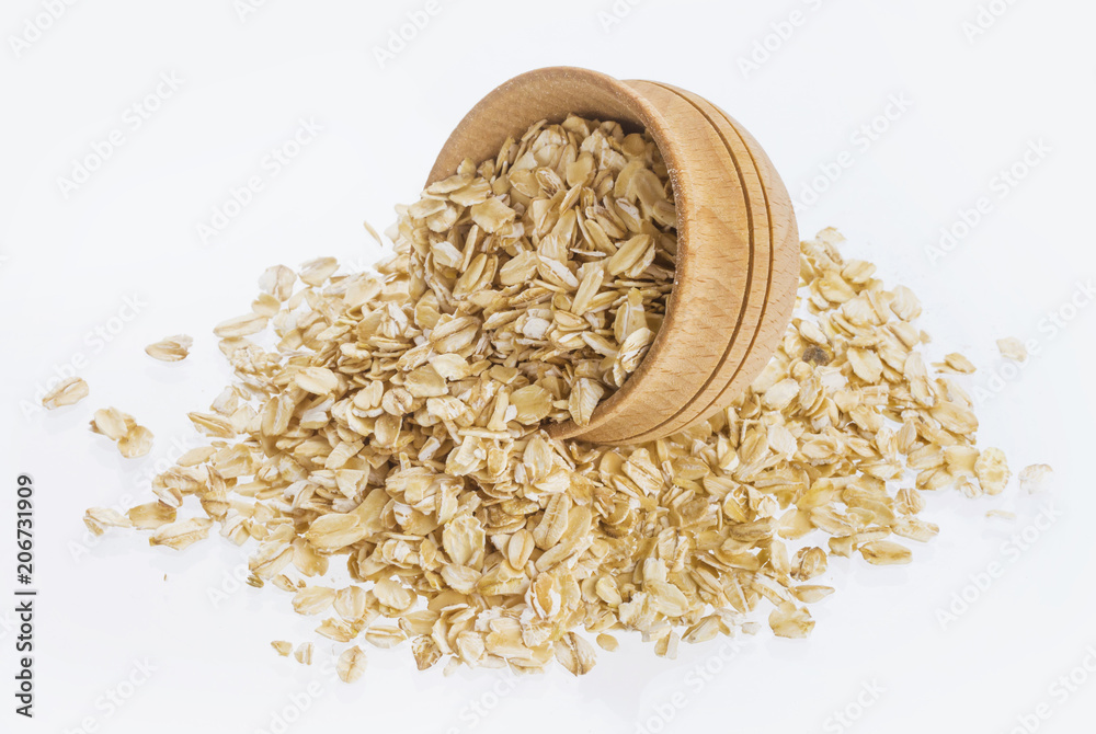 Oat flakes in wooden bowl isolated on white background Oat flakes in wooden bowl isolated on white background
