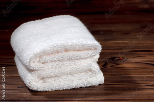 white cotton towels folded on wooden background, close up