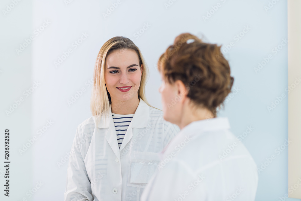 Mature doctor discussing with his colleague about the diagnosis at the hospital's office.