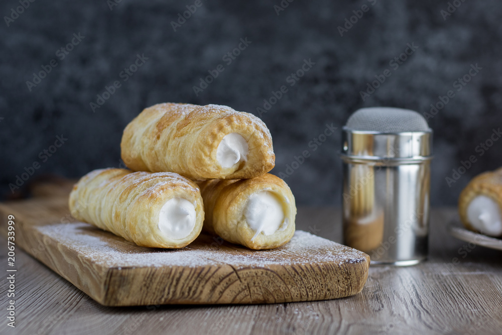 Three puff pastry creme rolle with cream (traditional Czech dessert) with a  sugar bowl Stock Photo | Adobe Stock