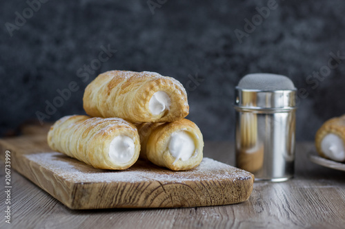 Three puff pastry creme rolle with cream (traditional Czech dessert) with a sugar bowl