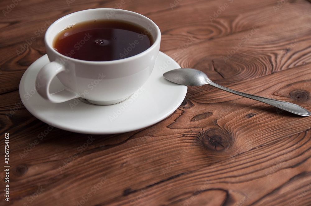 Obraz premium White cup of black tea or coffee on vintage wooden table