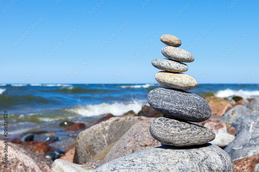 A pyramid of gray pebbles on the background of the storm sea A pyramid of gray pebbles on the background of the storm sea