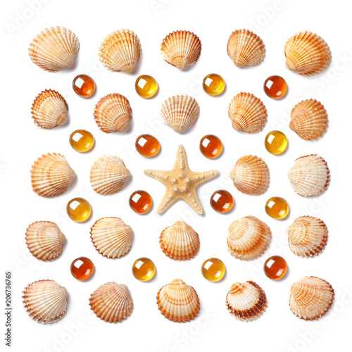 Pattern made of shells, starfish and orange glass beads isolated on white background
