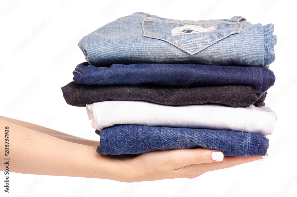 Stack of jeans in hand on a white background isolation Stack of jeans in hand on a white background isolation