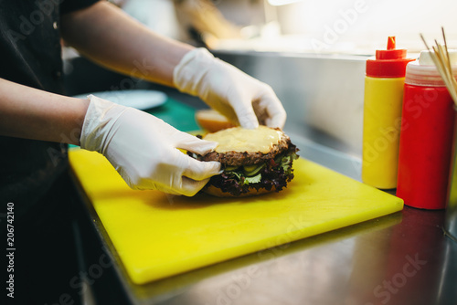 Male cook prepares fast food, burger preparation