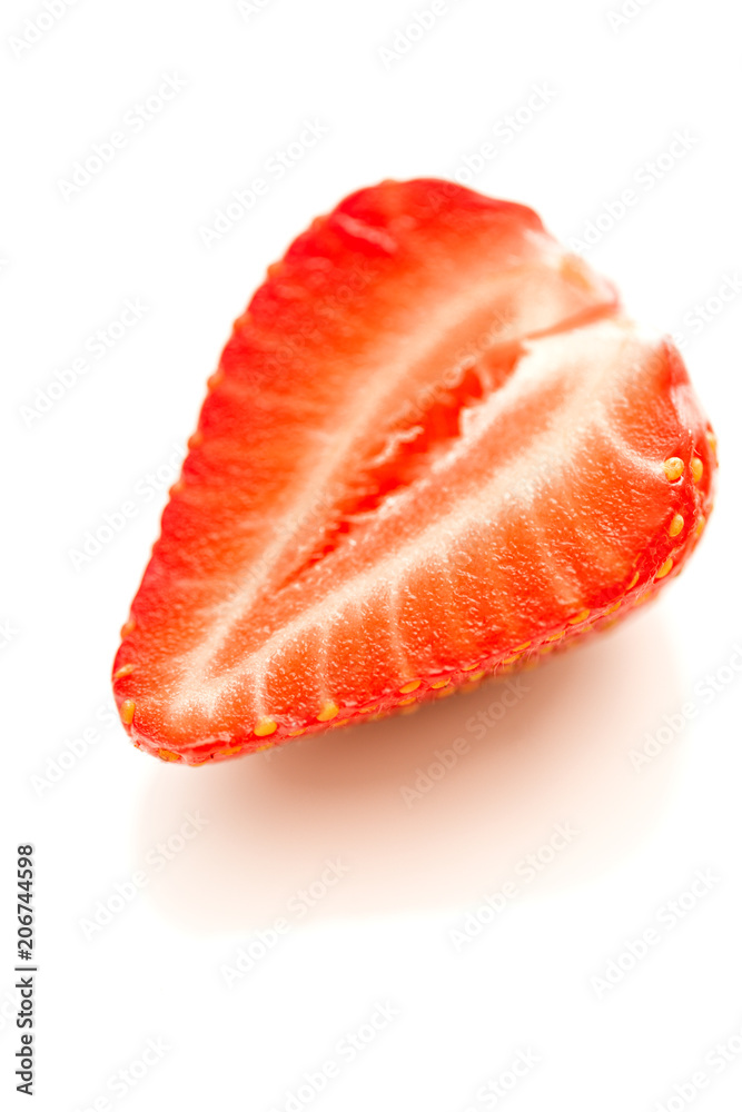 Halve of a strawberry on a reflective white background. Halve of a strawberry on a reflective white background.