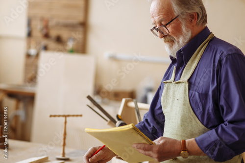 Fotografija pensioner is designing new project in the repair shop