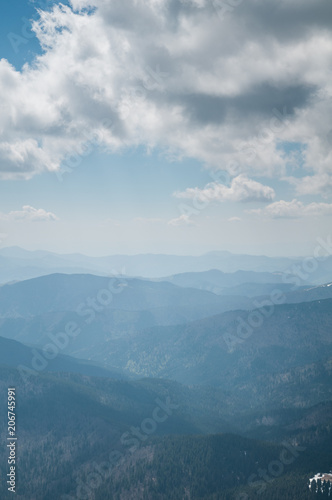 A beautiful view of the snow-capped mountains of the Carpathians from the top of Goverly in spring in a beautiful sunny day with light clouds. Carpathians  Goverla  Ukraine.