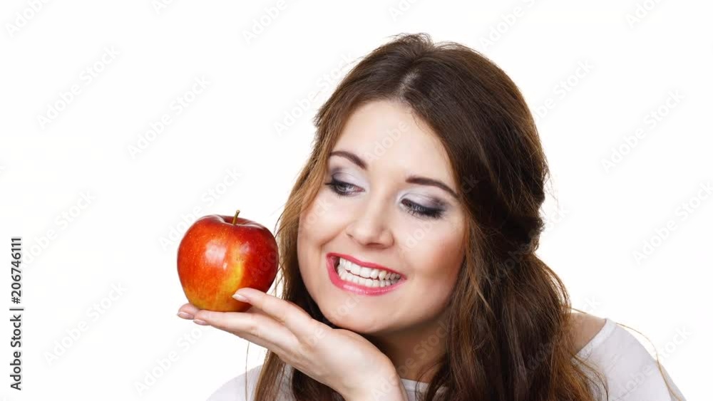 Woman toothy smile brunette female holding red apple fruit in hand close to face, isolated on white. Healthy eating, vegetarian food, diet concept. Woman toothy smile brunette female holding red apple fruit in hand close to face, isolated on white. Healthy eating, vegetarian food, diet concept.