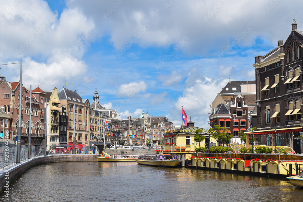 Colorful old houses and river restaurant on the banks of one of the channels of Amsterdam, Netherlands, Europe.