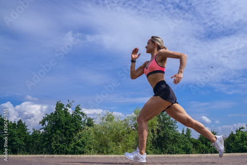 Fit woman running fast for sport on sunny day