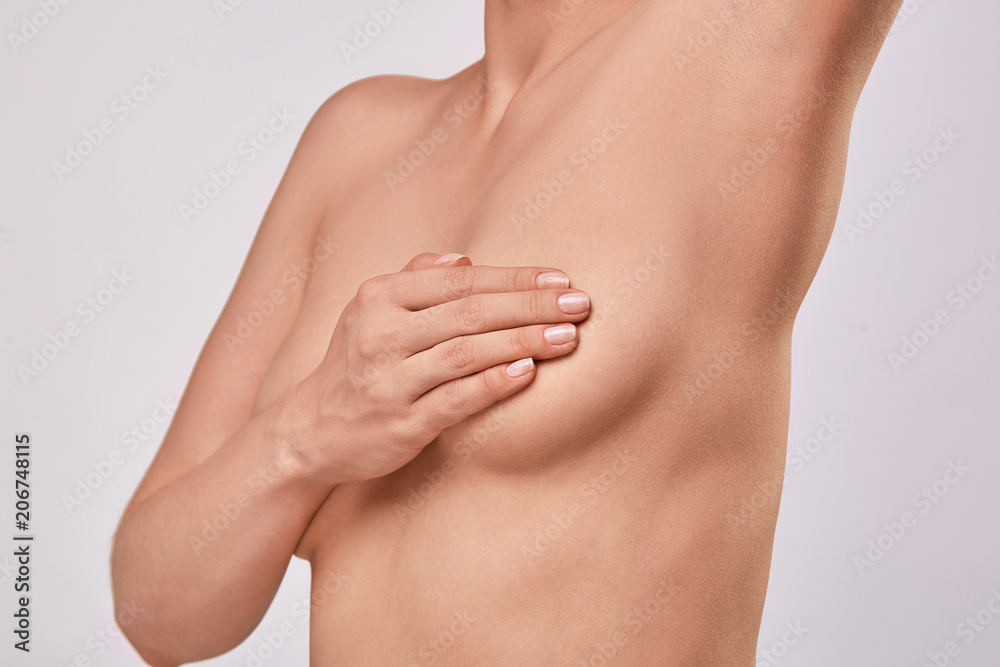 Young topless woman doing breast self-exam (BSE). Checking up breast changes, possible lumps, distortions or swelling. Breast cancer awareness. Young topless woman doing breast self-exam (BSE). Checking up breast changes, possible lumps, distortions or swelling. Breast cancer awareness.