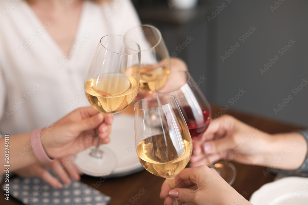 Young people with glasses of delicious wine at table