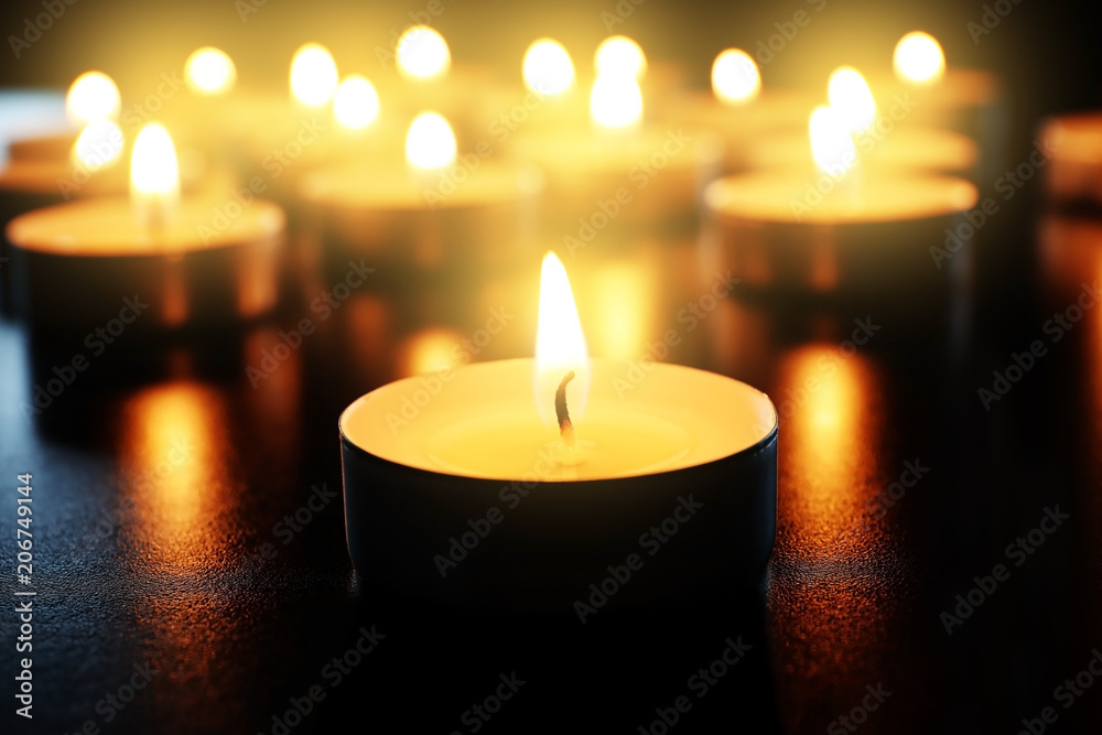 Wax candle burning on table in darkness, closeup Wax candle burning on table in darkness, closeup