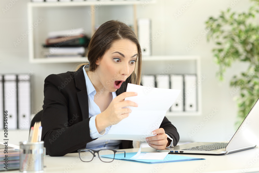 Amazed office worker reading a letter Amazed office worker reading a letter