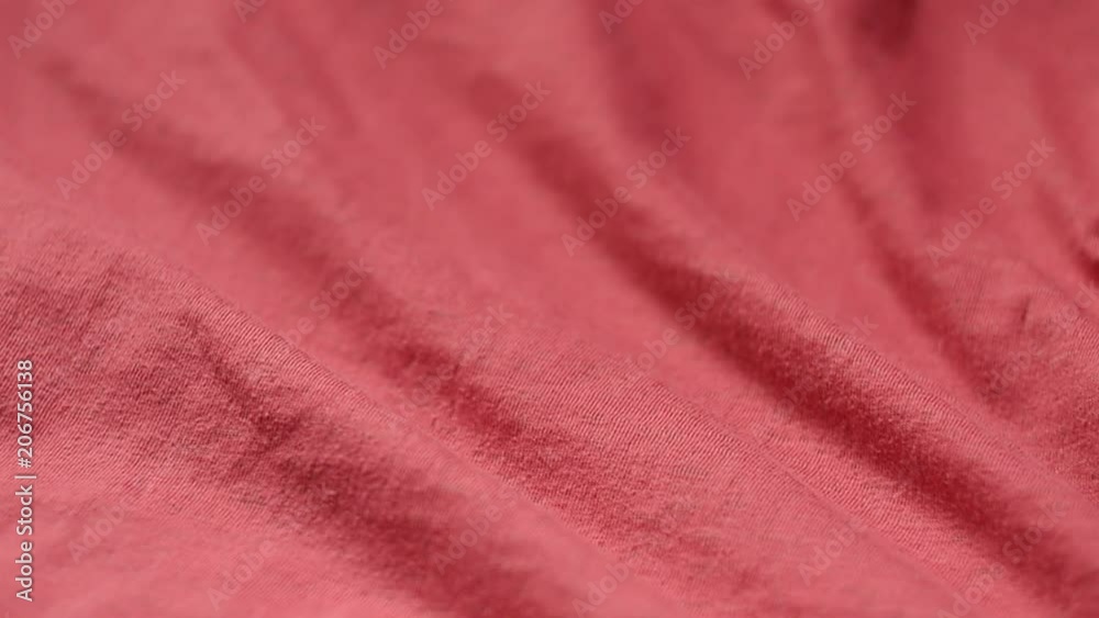 Slow panning shot of a red textile from polyester and cotton.