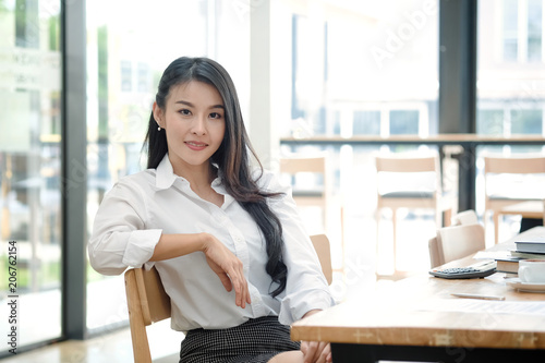 Portrait of attractive young asian woman sitting at home office in front of her laptop