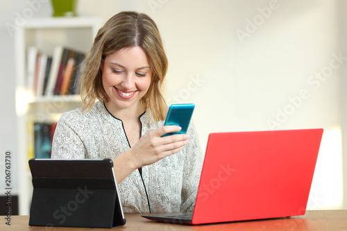 Happy female using multiple colorful devices at home