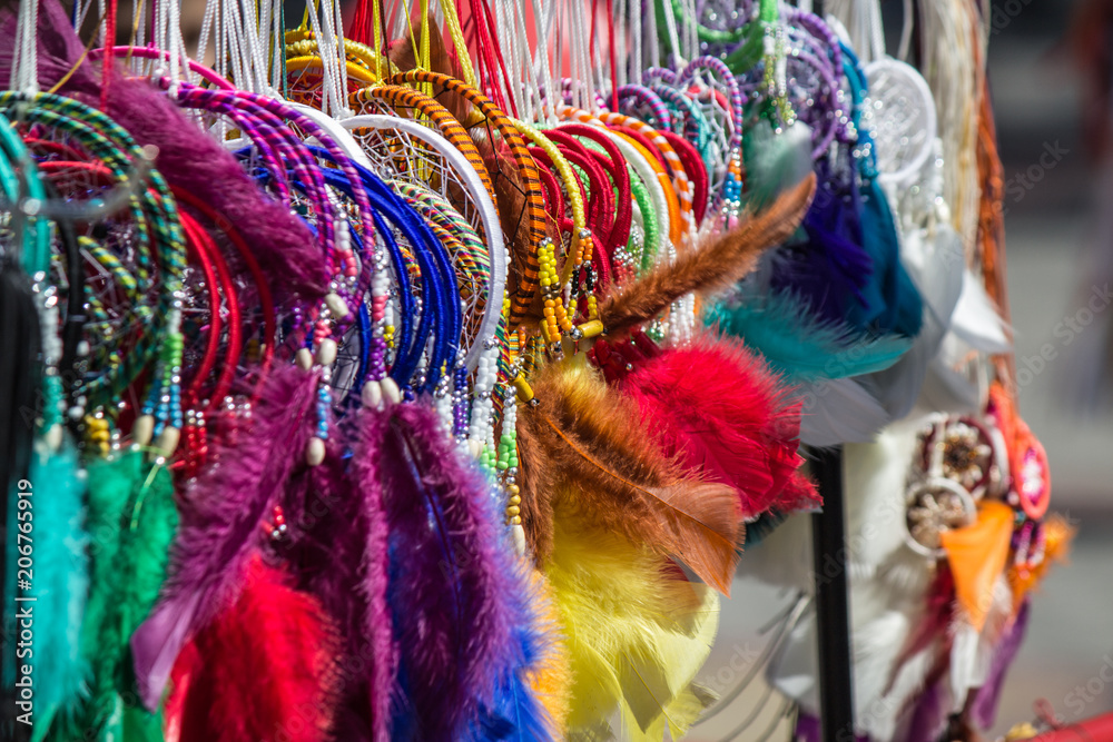 Fototapeta premium A lot of colorful bright dream catchers hanging on the counter of the market