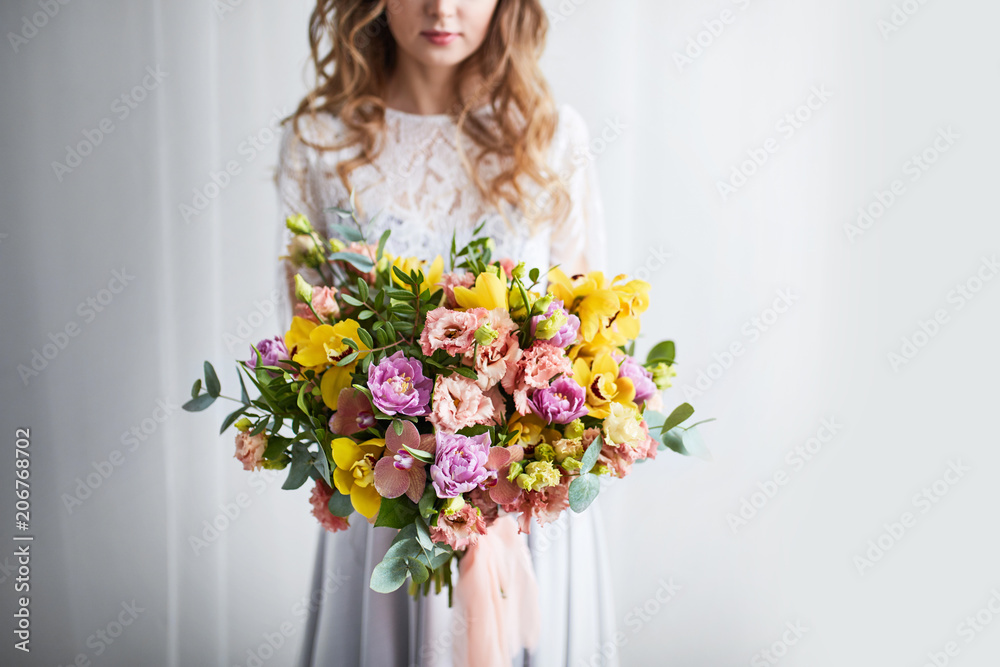 Spring bouquet of flowers with orchids, tulips and eustoma. Pink yellow flower arrangement Spring bouquet of flowers with orchids, tulips and eustoma. Pink yellow flower arrangement