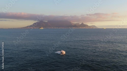 A whale breaching during sunset in Cape Town with Table Mountain in the background