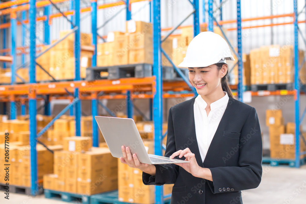 Female architect holding laptop with smiling at warehouse. People working concept. Female architect holding laptop with smiling at warehouse. People working concept.