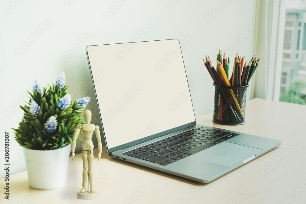Creative workplace with blank screen laptop on a desk in modern office. Creative workplace with blank screen laptop on a desk in modern office.