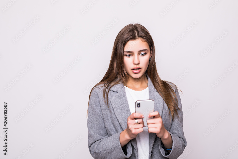 Portrait of a smiling casual woman typing on smartphone over white background Portrait of a smiling casual woman typing on smartphone over white background