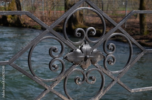 close-up of the black iron ornaments of a bridge's handrail
