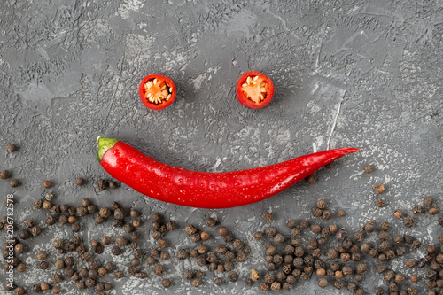 Chili pepper and peppercorns on stone background