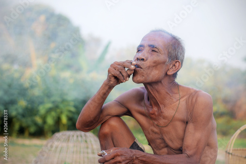 Older Asian men are smoking.